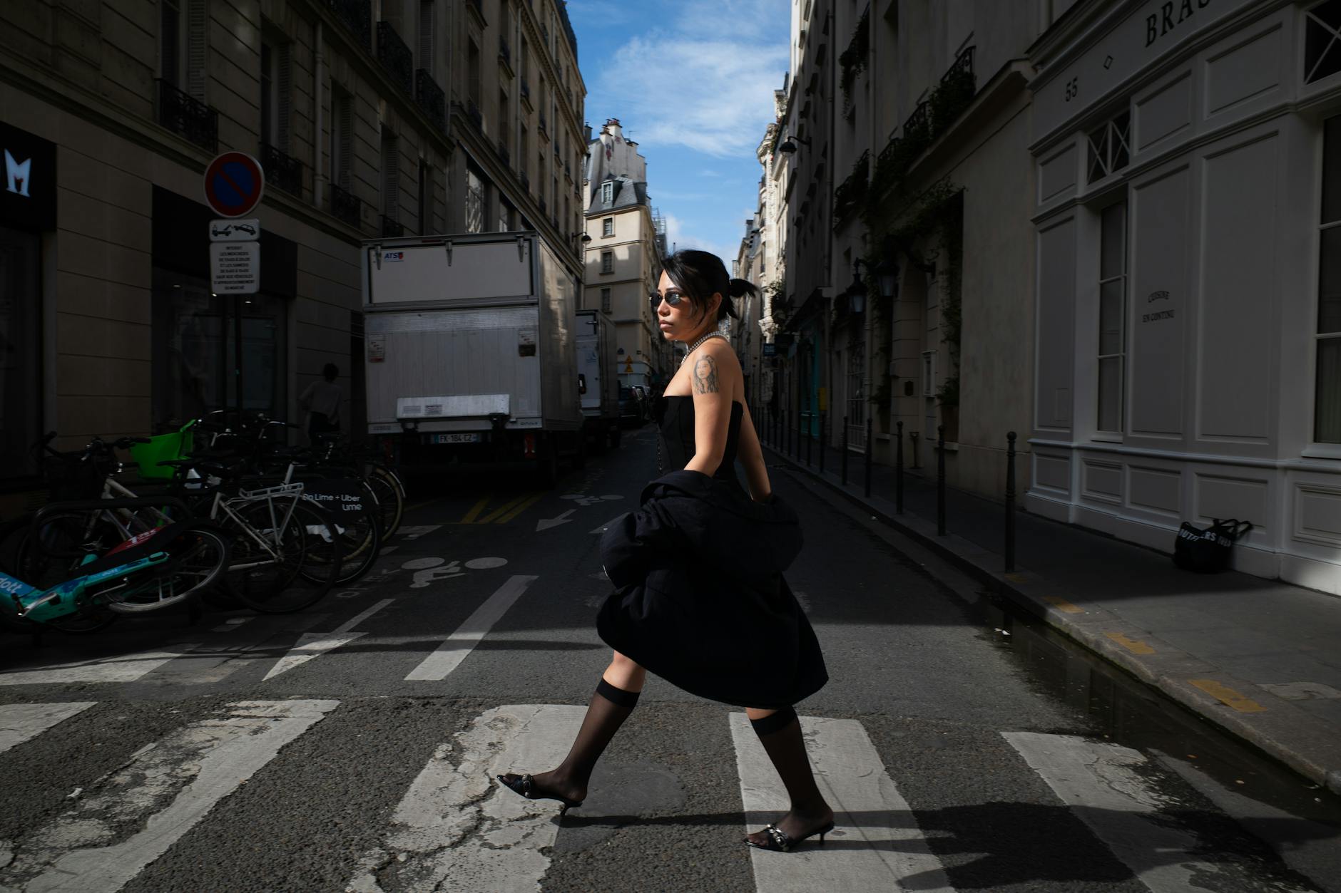 Elegancka kobieta przechodzi przez paryską ulicę w codziennej stylizacji