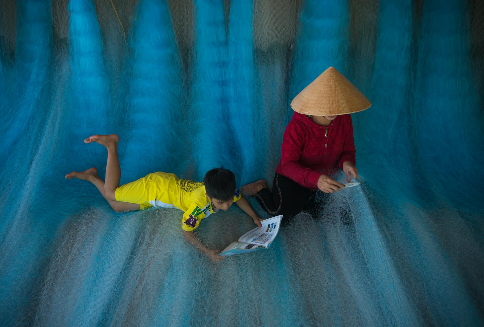 Mama z dzieckiem odpoczywają na kolorowych sieciach w Hội An