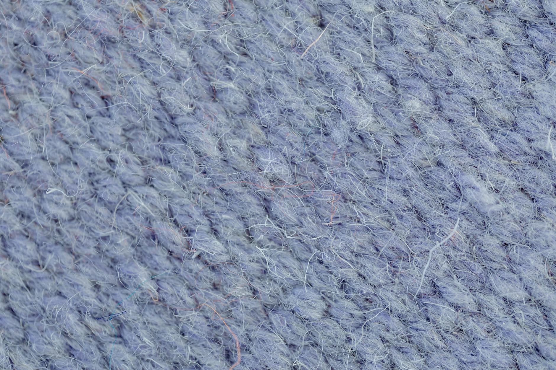 Zbliżenie niebieskiej dzianiny z wyraźnym splotem i fakturą