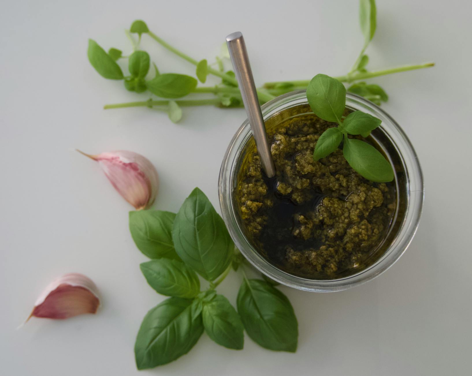 Miska domowego pesto bazyliowego z ząbkami czosnku i świeżą bazylią